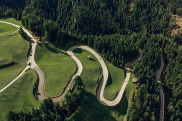 Aerial view of green summer forest with a road. Captured from above with a drone