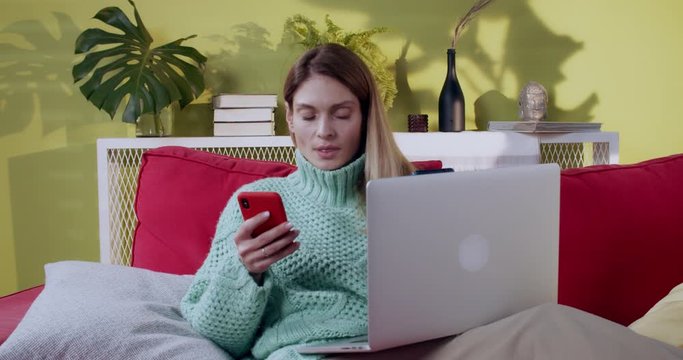 Busy modern internet woman using two smartphones and laptop computer immersed in technology. Doubtful candind woman shrugging sholders in hesitation.