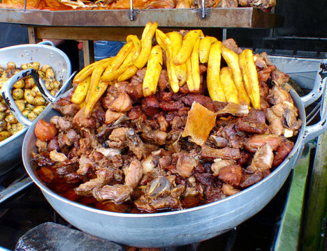 Fritada or fried pork, fried plantains, pigs skin, potatoes in big cooking bowls is traditional ecuadorian food which served at local restaurant in Cuenca