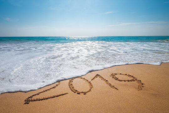 Old Year 2019 expires concept sandy tropical ocean beach lettering and Happy New Year 2020 is coming. Vacation at warm country concept image .