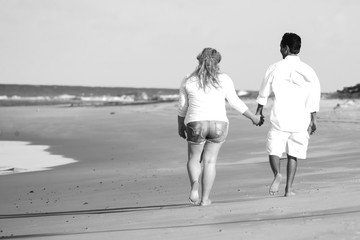 Fototapeta premium couple holding their hands walking on the beach, Valentine's Day