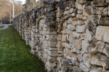 beautiful stone fence in the countryside lined with uneven pieces of limestone rock. Backdrop texture background