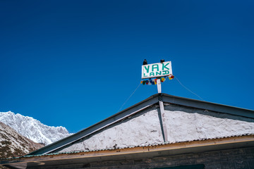 Crows sitting  on "YAK Land" sign on the lodge house with Lhotse Ridge background at Chukhung lodge village  4730 metres (15,518 ft), Khumbu Valley, Nepal.