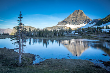 Stunning mountain reflection in alpine lake. Peaceful shoreline  on mountain lake.