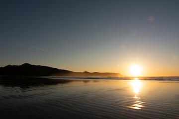 sunset over a sandy beach in tofino canada
