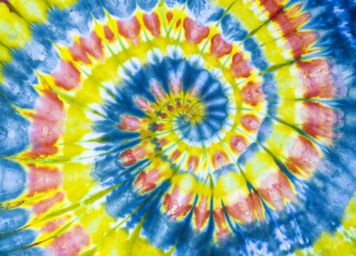 A bright yellow, red, and blue tye dye tunnel Fibonacci spiral pattern on cotton. © Dominic Gentilcore