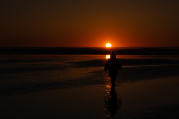 a child watches the sunset on a sandy beach in tofino vancouver island
