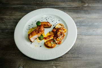 top view on trendy restaurant dish of grilled meat pieces with garnish