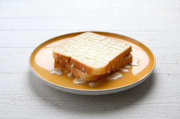Fresh homemade  baked bread and sliced bread with Sweetened Condensed Milk on wooden