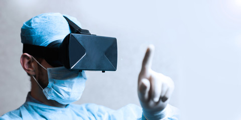 Doctor surgeon in uniform and helmet of virtual reality explores new technologies.
