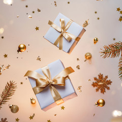 Merry Christmas card made of gold flying decorations, gift boxes, fir branches, snowflakes,...