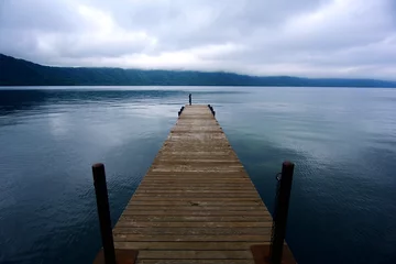 Keuken foto achterwand A wooden boardwalk pier extending to the lake, adding more stories to the tranquil lake. Imagine it is very beautiful © Konlon