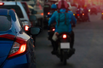Fototapeta na wymiar Luxury of blue car stop on the road and open brake light. with cars and other motorcycles on the road during heavy traffic with orange light