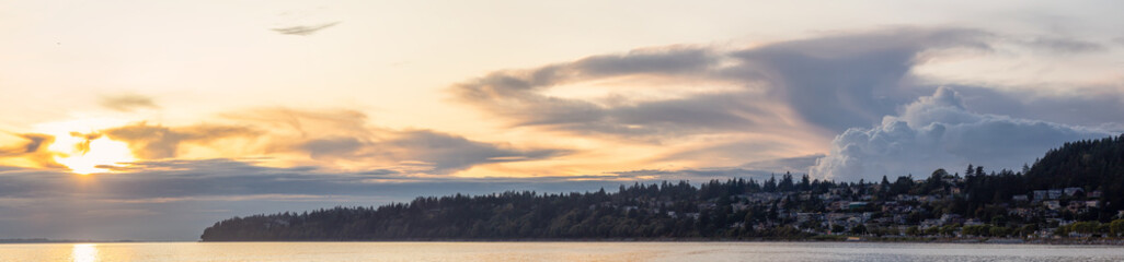 White Rock, British Columbia, Canada. Beautiful Panoramic View of Residential Homes on the Ocean Shore during a sunny and cloudy summer sunset.