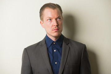 Face of young handsome businessman in suit thinking