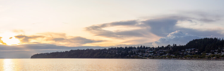 Naklejka na ściany i meble White Rock, British Columbia, Canada. Beautiful Panoramic View of Residential Homes on the Ocean Shore during a sunny and cloudy summer sunset.
