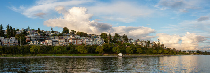 White Rock, British Columbia, Canada. Beautiful Panoramic View of Residential Homes on the Ocean Shore during a sunny and cloudy summer sunset.