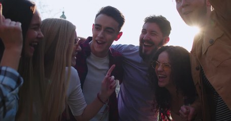 Caucasian young people having fun while laughing and dancing outside. Men and women spending time nice together in the city. - Powered by Adobe