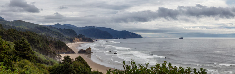 Fototapeta na wymiar Ecola State Park, Cannon Beach, Oregon, United States. Beautiful Panoramic View of the Sandy and Rocky Beach on Pacific Ocean Coast during a cloudy summer day.