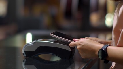 Young woman using smartphone to payment with credit transaction