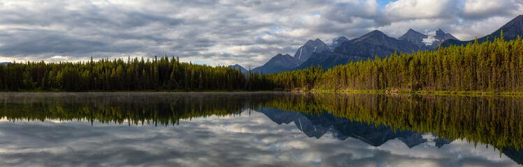 Fototapeta na wymiar Beautiful Panoramic View of Herbert Lake surrounded by Canadian Rocky Mountain Landscape during a summer sunrise. Taken in Banff, Alberta, Canada.