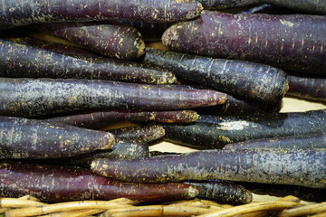 Colorful purple heirloom carrots at a farmers market