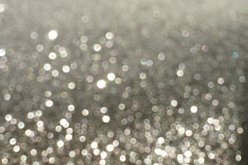 Silver Sparkling Lights Festive background with texture. Abstract Christmas twinkled bright bokeh defocused and Falling stars. Winter Card or invitation	