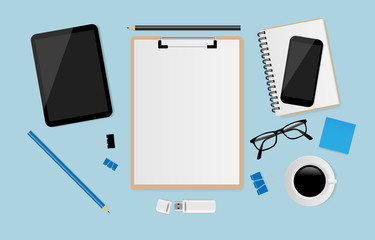 Blank white sheet on clipboard with pencil, smartphone, notebook, eyeglasses, coffee cup, digital tablet and post it paper on blue background