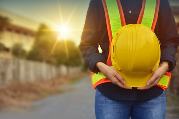 Worker Engineer holding Yellow helmet hard hat safety standing against sunlight background project manager professional