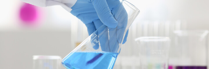 A male chemist holds test tube of glass