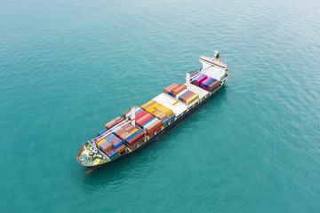 Stunning aerial view of a cargo ship sailing with hundreds of colored containers direct to the port...