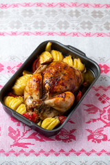Spicy roasted baked chicken with potatoes.  Festive bird baked with vegetables on the table