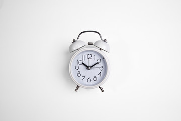 a white alarm clock. a white clock on top of a white background