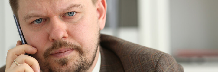 Obraz premium Handsome smiling businessman talk cellphone