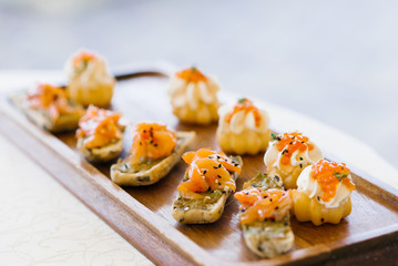 Snacks with salmon or salmon on a wooden plate or Board close up with selective focus