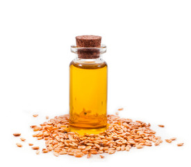 Flax seed oil in a glass bottle and white linen seeds isolated on white background