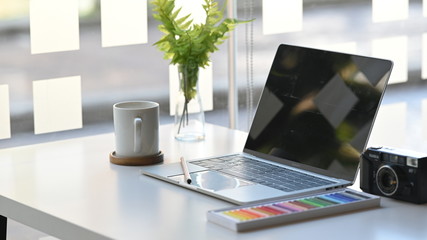 Laptop computer, camera, color, plant decorate and coffee on white table.