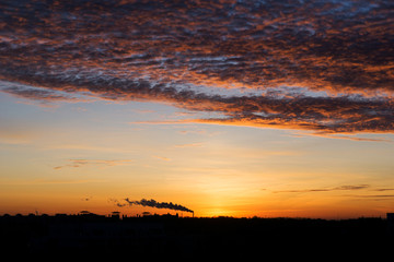 Fototapeta premium Sunset over city scape. Silhouette City Sunset with dramatic red and ornage sky