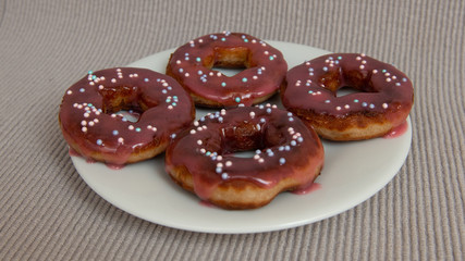 assorted donuts with chocolate frosted, pink glazed and sprinkles donuts