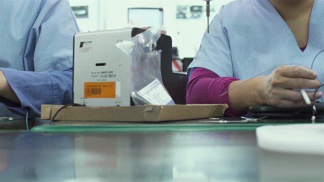 Assembly Line Female Workers Manufacturing Laptop Computers. Dolly Shot.
