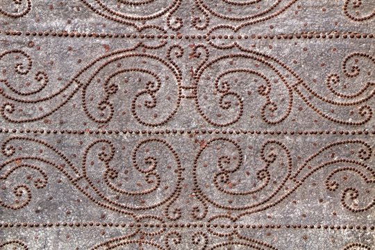 Gray metal door with wrought iron details