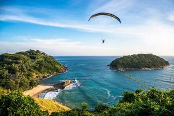 Paragliding Extreme sport, Paraglider flying on the blue sky and white cloud in Summer day at Phuket Sea, Thailand. - obrazy, fototapety, plakaty
