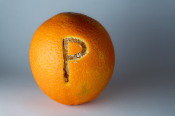 Buchstabe p einer Schriftart in die Schale frischer Orangen geschnitzt