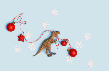 Dinosaur Plastic toy with Christmas red balls, snowflakes. Christmas and New Year holiday...