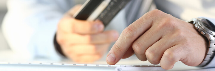 Male arms hold credit card press buttons