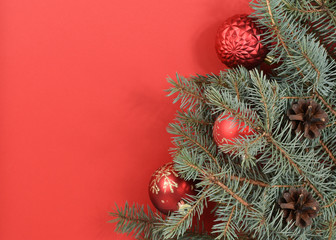 Christmas decoration. Red balls, Christmas tree, white wall, red background. Place for an inscription. New Year card. Christmas card.