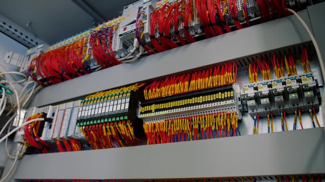 Inside of electrical control panel with multiple switches, wires, short circuit protection devices, electricity meter. Color cable terminal socket and electrical control device. Smooth panning