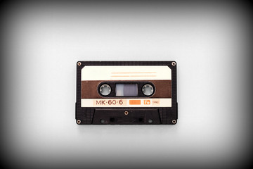 Audio tape cassette on a gray background close-up, top view. Old Technology Concept
