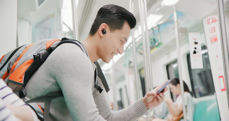 asian man wear wireless earbuds - obrazy, fototapety, plakaty
