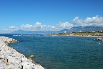View across the bay towards the beach and mountains, Cabopino, Marbella, Spain.